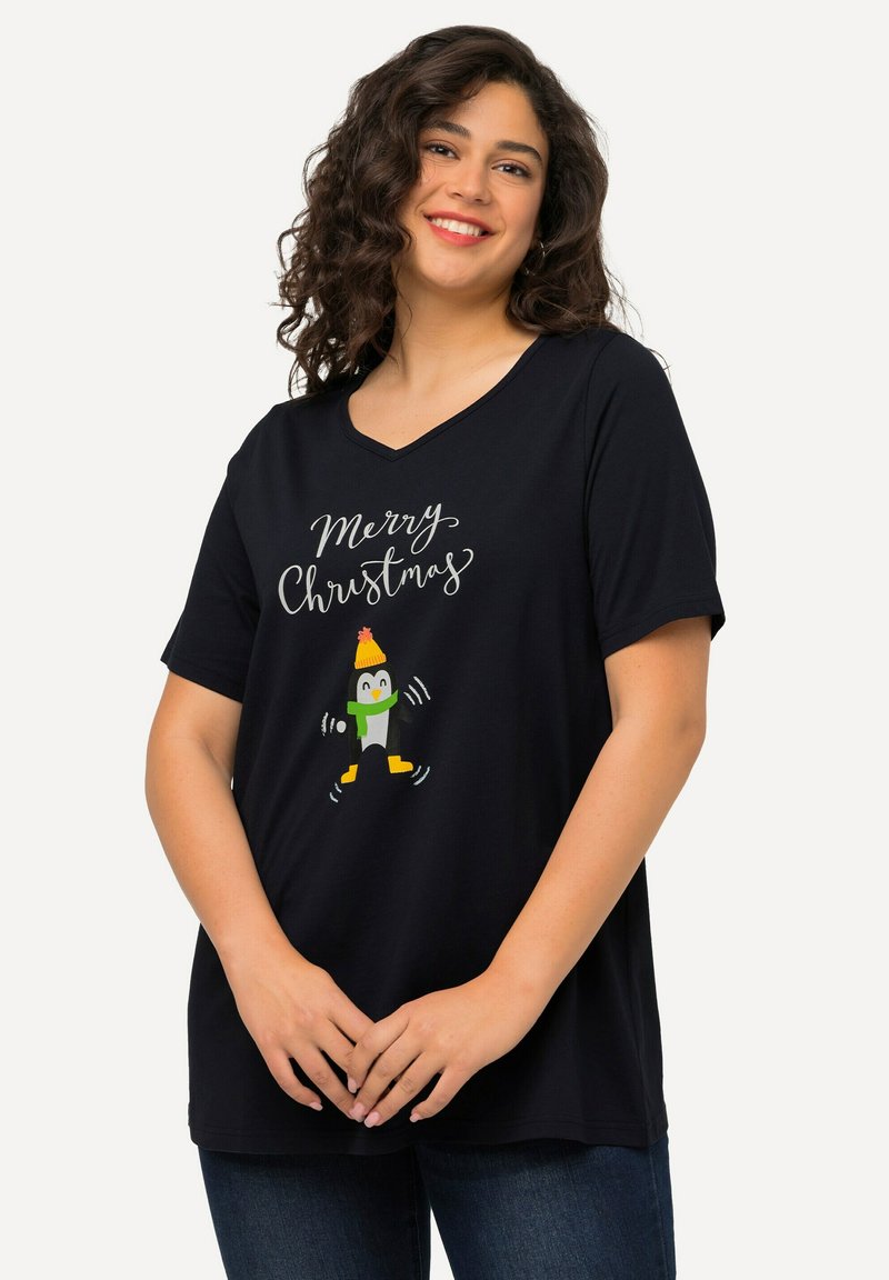 Camiseta negra de algodón con escote en V, que presenta un gráfico festivo de un pingüino y el texto "Feliz Navidad" en blanco. Con mangas cortas y corte relajado.