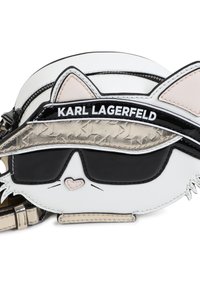 Sac en bandoulière en cuir blanc en forme de tête de chat, avec des lunettes de soleil noires, des accents roses et la marque 'Karl Lagerfeld'.