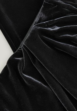 Schwarzer Samtstoff mit einer glatten, weichen Textur, der drapierte Falten und einen subtilen Glanz aufweist, ideal für Bekleidung oder Polsterungen.