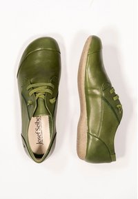 Scarpe in pelle verde con punta rotonda, design con lacci, dettagli di cucitura sottili e suola beige testurizzata. Presentano un materiale morbido e flessibile.