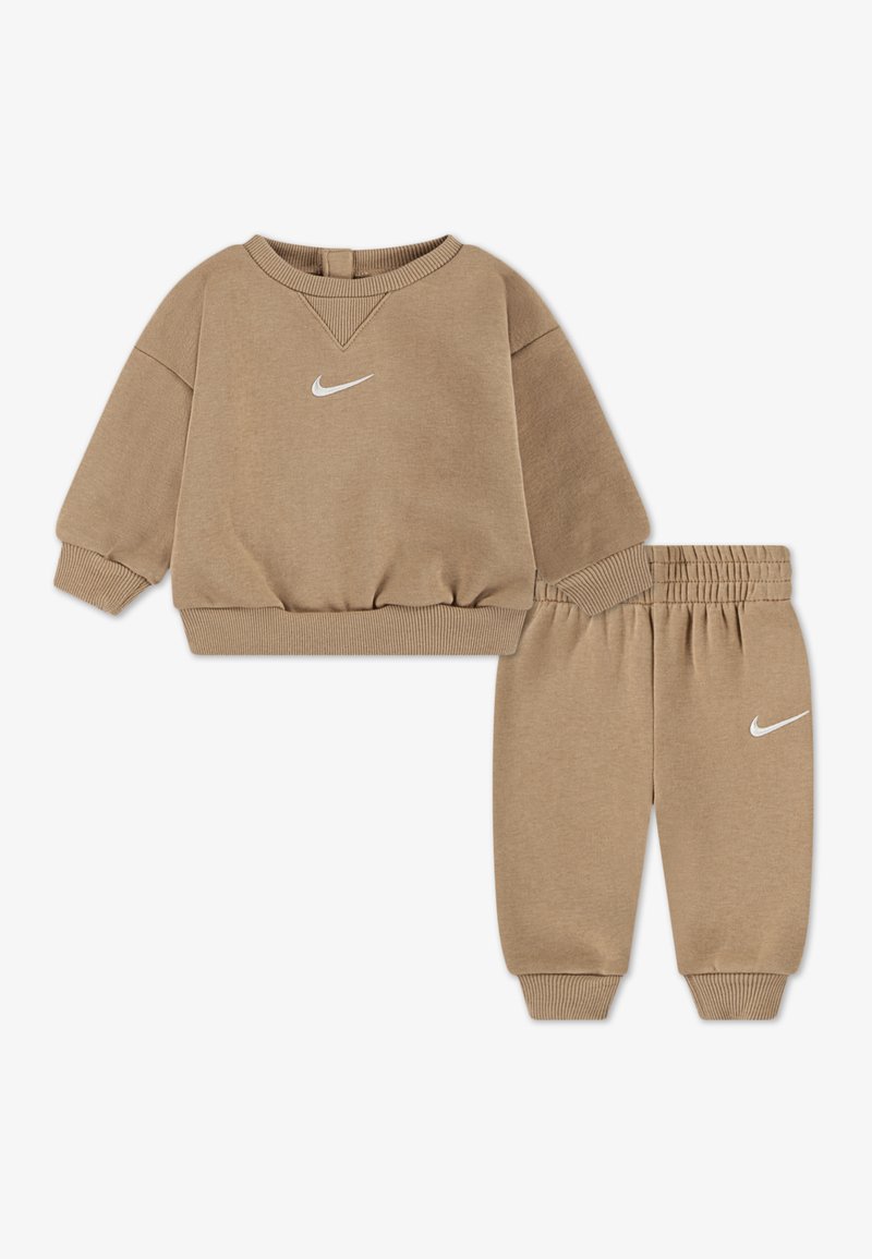 Beige värinen lasten urheilupuku, joka koostuu pitkähihhaisesta pyöreäkauluksisesta collegepaidasta ja joustavavyötteisistä collegehousuista.