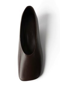 Chaussure plate en cuir marron foncé avec un bout carré et une texture lisse, vue de dessus sur un fond blanc.
