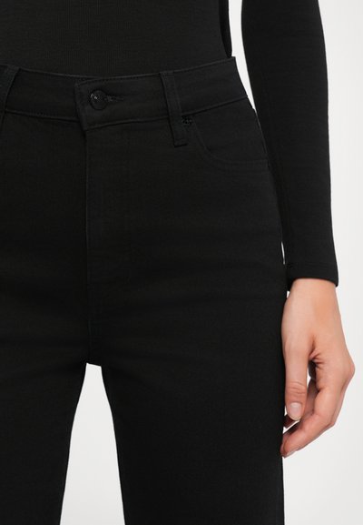 Black denim jeans with a slim fit, featuring front pockets, a button closure, and a smooth texture. Minimalist design, no visible patterns.