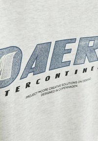 Szary bawełnowy sweatshirt z wyrazistym niebieskim napisem w zniszczonym stylu, z wyrazem "DAER" oraz dodatkowymi szczegółami marki poniżej.