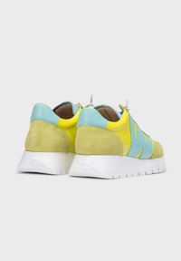 Zapatillas de ante y cuero en amarillo, verde y azul. Punta redondeada, suela de goma blanca con detalles texturizados y cierre con cordones.