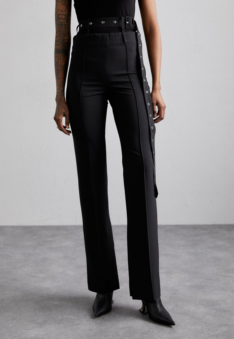 Black high-waisted trousers with a side snap closure, metal accents, and straight-leg design. Material appears smooth with slight sheen.