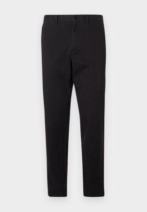 Schwarze Slim-Fit-Hose mit Knopfverschluss, Gürtelschlaufen und zulaufenden Beinen, vor einem hellgrauen Hintergrund dargestellt.