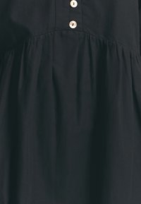 Schwarzes Kleid mit einem taillierten Oberteil, Knopfleiste, geraffer Taille und fließendem Rock. Hergestellt aus einem weichen, strukturierten Stoff.