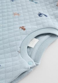 Lysblå babybody med en quiltet tekstur, der har små dyremotiver i forskellige farver, ribbet krave og trykknaplukning.