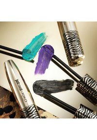 Tre mascara-børster med turkise, lilla og svarte mascara-striper ved siden av gullfargede og sebramønstrede Just Cavalli x KIKO-tuber.
