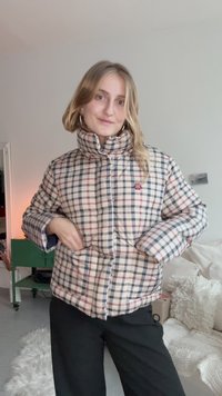 Polstret ternet jakke i beige, navy og røde nuancer med høj krave og trykknapper. Har to sidelommer og et logo-patch.