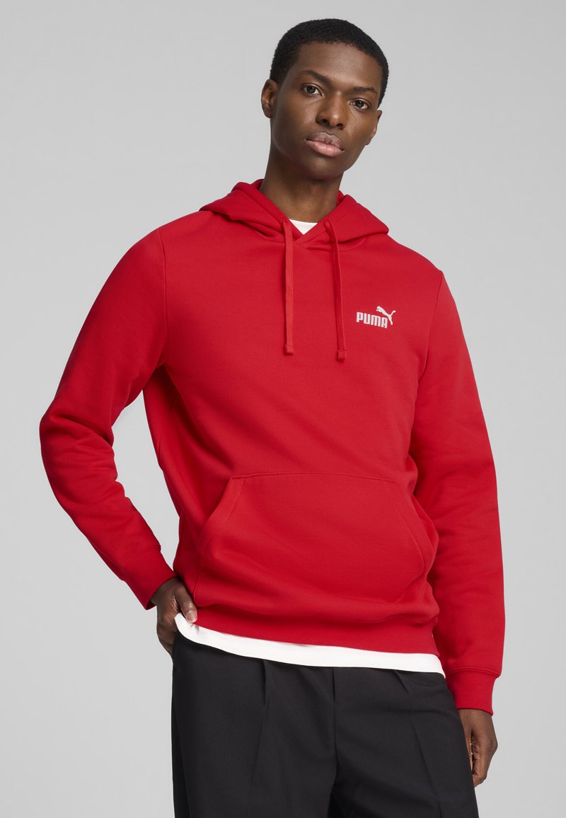 Rote Kapuzenjacke mit Kängurutasche, aus weichem Material gefertigt. Mit einem weißen Puma-Logo auf der oberen linken Seite und einer Kordelzugkapuze.