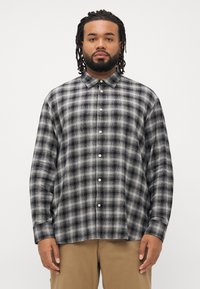 Zwart en grijs geruite button-up shirt met lange mouwen, een kraag en witte knopen, gemaakt van een zachte, gestructureerde stof.