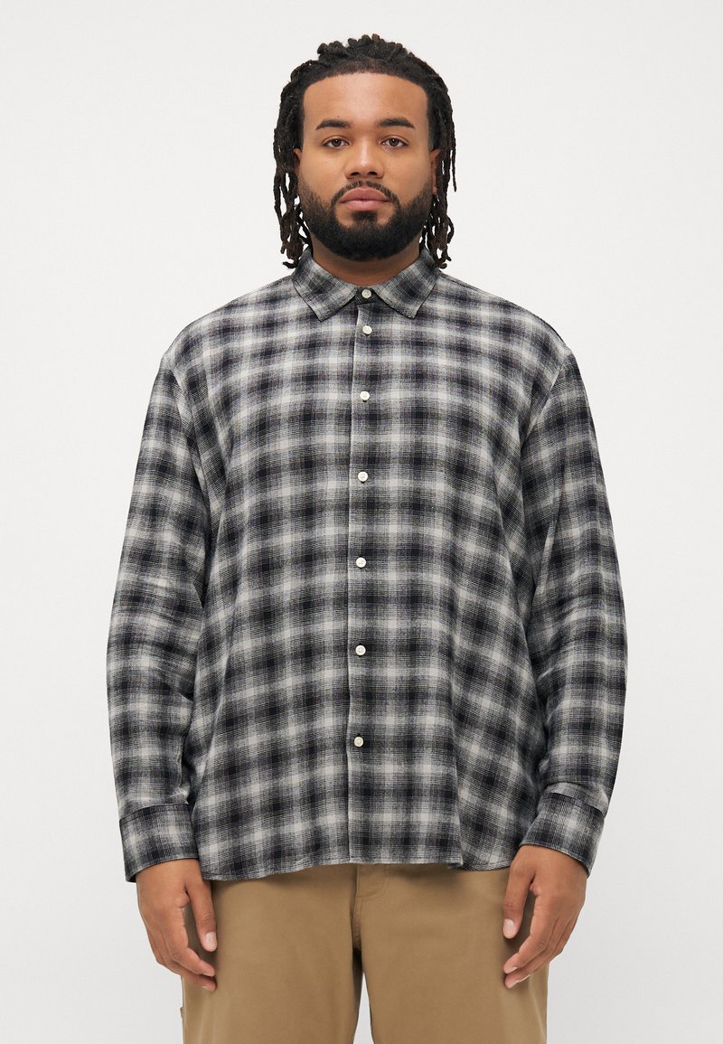 Zwart en grijs geruite button-up shirt met lange mouwen, een kraag en witte knopen, gemaakt van een zachte, gestructureerde stof.