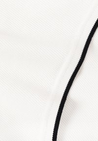 Tissu blanc avec une texture côtelée fine et une seule bande noire étroite traversant en diagonale.