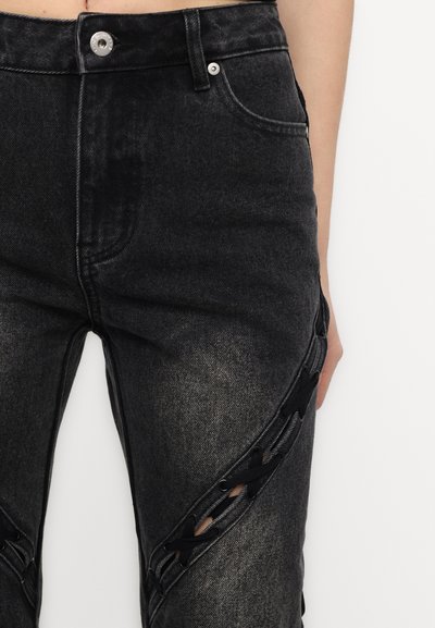 Černé džíny z denimu s vybledlým vzhledem, s detailní šněrováním po stranách a standardním pasem s předním zapínáním na knoflík.
