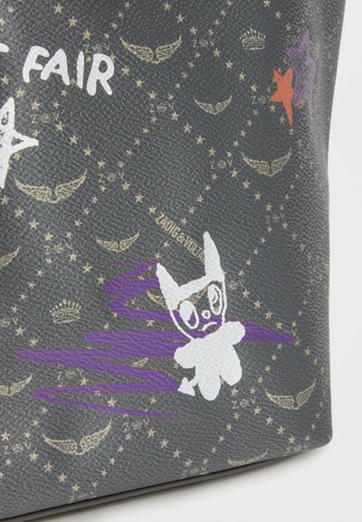 Σκοτεινή υφή επιφάνειας με χρυσά λογότυπα φτερών και κείμενο, λευκή και μοβ αφηρημένη φιγούρα κουνελιού, και διάσπαρτα αστέρια και χειρόγραφο κείμενο.