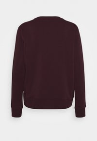 Sudadera burdeos con cuello redondo, mangas largas, puños y bajo de canalé. Textura lisa, sin logotipos ni patrones visibles. Vista trasera mostrada.