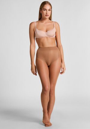 Beige padded bra with thin straps, paired with high-waisted, sheer brown tights. Smooth texture, seamless design, form-fitting silhouette.