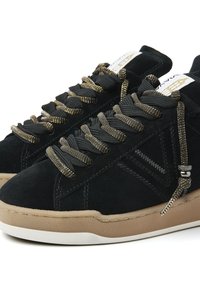 Black suede sneakers with a textured brown rubber sole. Features metallic gold and black laces, and subtle side stitching details.