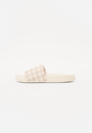 Beige Slide-Sandale mit einem strukturierten Riemen, der ein dezentes Logomuster zeigt, und einer flachen, gepolsterten Sohle. Glattes Gummimaterial.