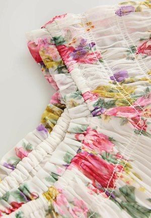 Floral-patterned chiffon dress with gathered fabric detailing. Predominantly white with pink, red, and green flowers. Soft, textured finish.