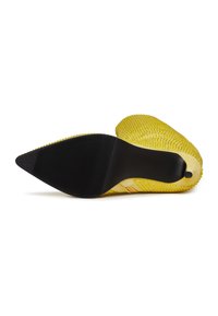 Pantof cu toc înalt galben, cu un material texturat și vârf ascuțit. Talpă din cauciuc negru cu caneluri pentru aderență. Model notabil pe țesătură.