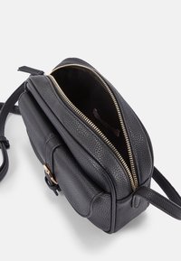 Bolso de cuero negro con un acabado texturizado, cremallera dorada y una correa ajustable. Cuenta con un compartimento principal y un bolsillo frontal.