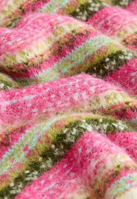 Texturált kötött anyag rózsaszínben, zöldben és kékben, hullámos mintával és puha, bolyhos megjelenéssel; fehér pettyes díszítéssel.