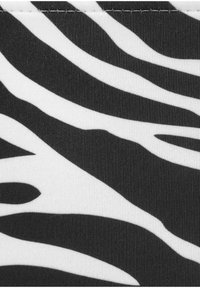 Schwarz-weiß gestreifter Stoff mit einem gewellten Zebra-Muster, das eine gerippte Textur und klare, präzise Linien im gesamten Design aufweist.