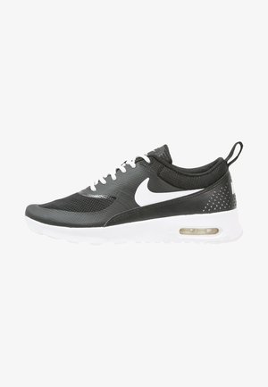 Czarno-biała tenisówka Nike Air Max z białym logo Swoosh, widoczną poduszką powietrzną w podeszwie oraz białymi sznurowadłami na białym tle.