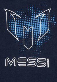 Mornarsko plava majica s grafičkim dizajnom koji sadrži plave točkaste akcentne detalje i bijelo slovo "MESSI" ispod stiliziranog logotipa.