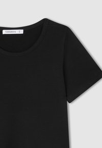 T-shirt nera a maniche corte realizzata in tessuto liscio, con scollo rotondo e cuciture curate sulle maniche e sull'orlo. Etichetta visibile sul colletto.