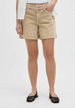 Shorts in denim beige con orlo leggermente strappato, due tasche anteriori e chiusura con bottone. Abbinati a ballerine in rete nere.