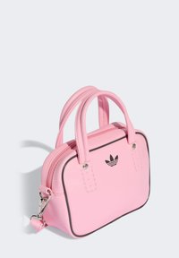 Ružová kabelka z umelého kože s čiernymi doplnkami, dvojitými rúčkami a zipsovým uzavretím. Na prednej strane sa nachádza malé čierne logo a detaily šitia.