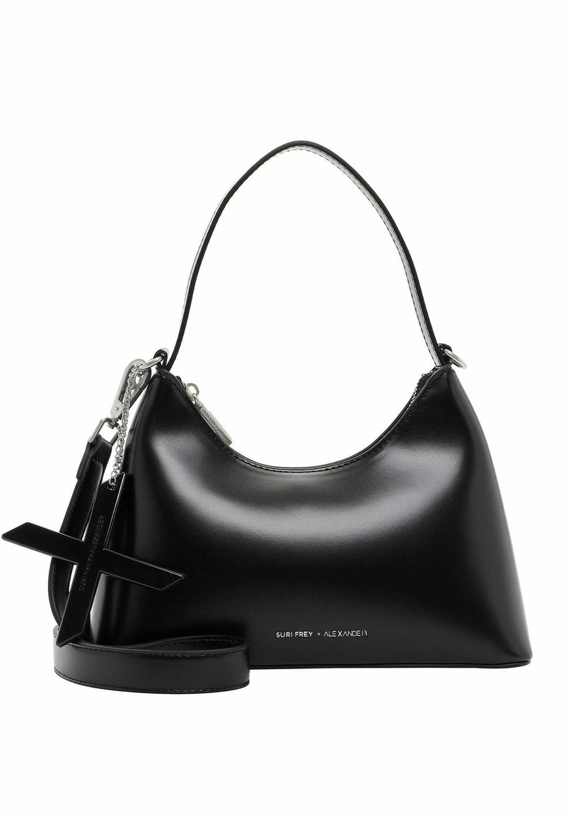 Sac à main noir brillant avec une poignée supérieure courbée, un grand pendentif en forme de croix et un petit texte argenté près du bas indiquant SURI FREY x ALEXANDER.