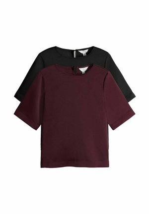Short-sleeve top set in burgundy and black. Features a round neckline, smooth texture, and zipper detail at the back of each shirt.