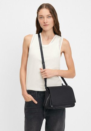 Borsa a spalla in pelle nera con chiusura a pattina e dettagli con zip. Texture liscia, tracolla regolabile, design minimalista.
