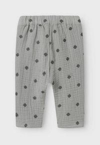 Leggings pour bébé gris en tissu texturé, avec une taille élastique douce et des motifs de petits points noirs sur l'ensemble.