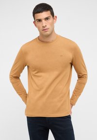 Langärmliges, rundhalsiges Shirt in einem warmen Braunton, aus weichem Stoff mit einem dezenten Logodetail auf der Brust. Klassische Passform und glatte Textur.