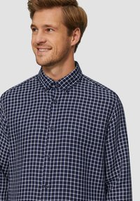Marineblauwe geruite overhemd met een button-down kraag, voorzien van een rasterpatroon in het wit. De stof lijkt zacht met een gladde textuur.