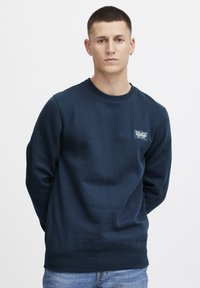 Marineblauwe sweatshirt van een zachte katoenen mix, met een ronde hals, ribbelmanchetten en een klein wit logopatch op de borst.