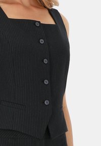 Czarny kamizelka w paski z kwadratowym dekoltem, z czterema guzikami, dopasowany krój i minimalistyczny design. Zawiera skośne boczne kieszenie.