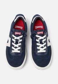 Baskets marines avec des accents blancs, dotées d'un dessus en tissu texturé, d'un système de laçage et d'une fermeture éclair, ainsi que d'une semelle intérieure rouge avec le logo "CAMPER".