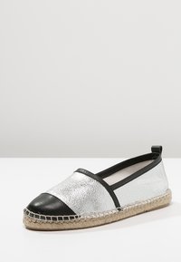 Espadrille à enfiler en argent métallisé et noir avec une semelle en jute, présentant une finition texturée et des accents en cuir lisse.