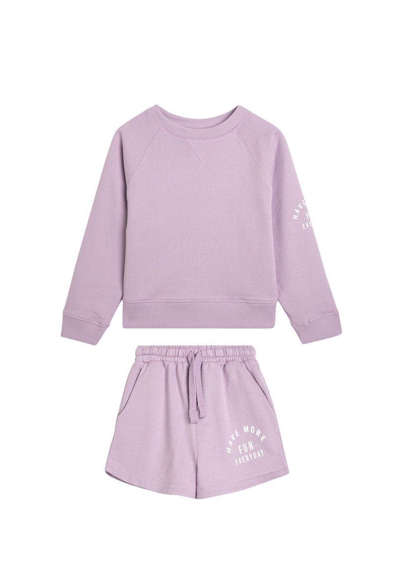Violet loungewear-setti sisältää pyöreäkaulustakin ja matching naruhousut. Housuissa on valkoista tekstiä yksityiskohtana.