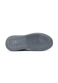 Suela de zapato de goma gris con patrones texturizados y ranuras para mayor agarre. Presenta un borde exterior suave y una zona de punta redondeada.