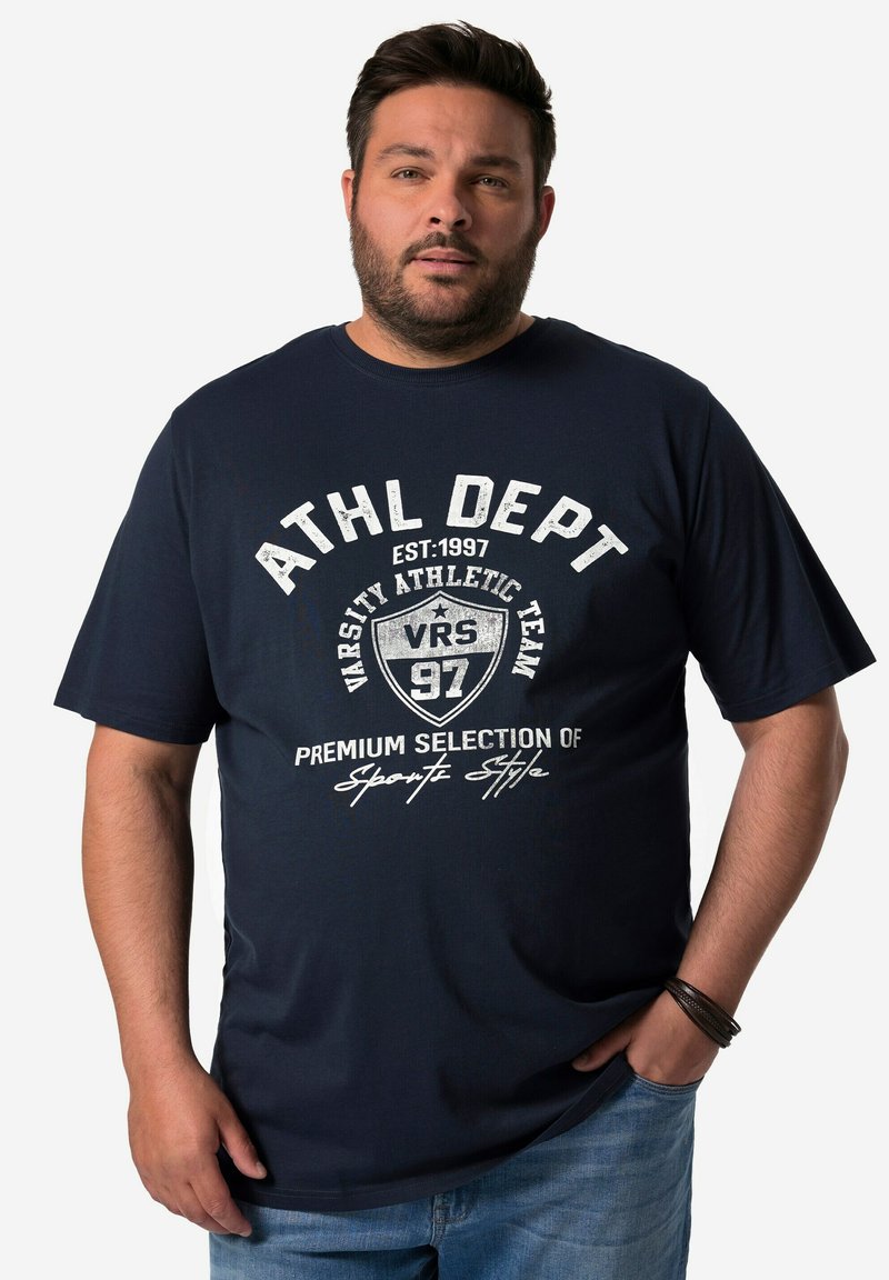 Tmavě modré bavlněné tričko s bílým potiskem textu. Kulatý výstřih a krátké rukávy s volným střihem, stylizované pro neformální nošení.