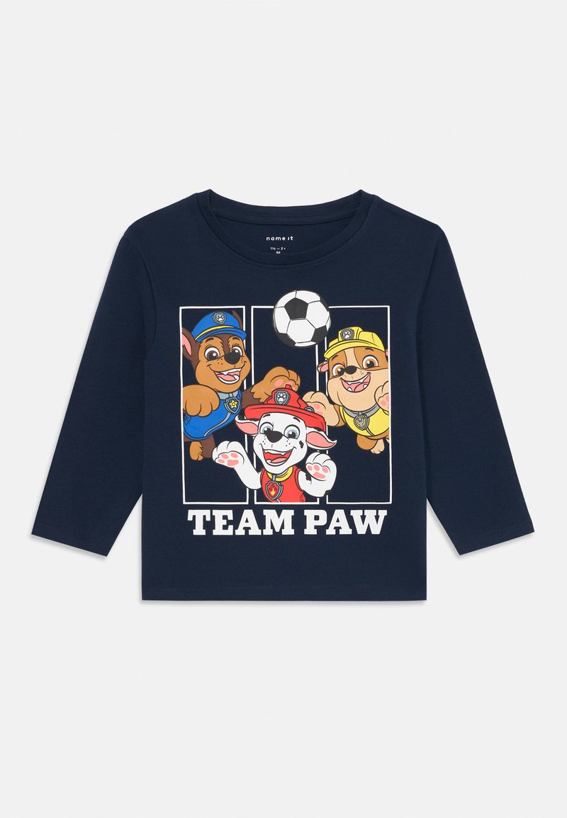 Jūras spēku ilgu piedurkņu T-krekls, kas izgatavots no kokvilnas, ar grafiku, kurā attēloti trīs multfilmu suņi un futbola bumba, zem kuras ir teksts "TEAM PAW".