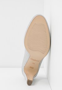 Semelle d'une chaussure à talon haut argentée avec une semelle texturée, taille 4½, marque Gabor, fabriquée au Portugal, présentée sur fond blanc.